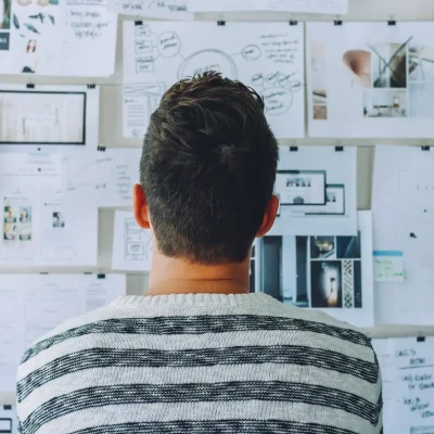Photo by Startup Stock Photos: https://www.pexels.com/photo/man-wearing-black-and-white-stripe-shirt-looking-at-white-printer-papers-on-the-wall-212286/